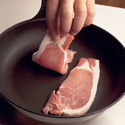 身が厚い豚ソテー用肉に中まで火を通す場合、フライパンを熱する前に肉を並べ、火にかけて徐々に温度を上げていく。熱したフライパンに肉を入れると、急激に熱が伝わり、身がしまってかたくなり、パサついてしまう。