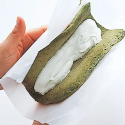 両手でゆっくりとはさむように生地を持ち上げ、生地の端が合わさったらペーパーで包む。