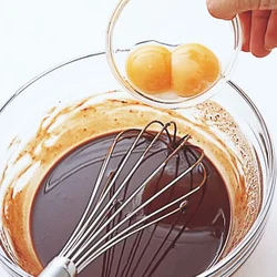 チョコレートとバターがなじんでなめらかになったら、卵黄を加えて混ぜる。
