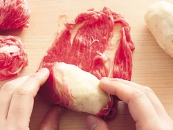 つぶしたじゃがいもは俵形にし、牛肉を広げて巻きつけていく。全体が均一の厚みになるようにする。