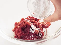 牛肉は下味をつけて臭みを取り、風味をよくする。さらにうまみを閉じ込めるために片栗粉をまぶす。
