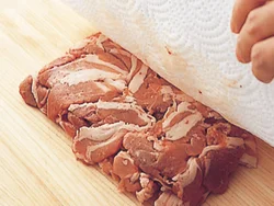 パックに流れ出た肉の汁けは臭みのもとになるので、ペーパータオルで押さえてふき取る。