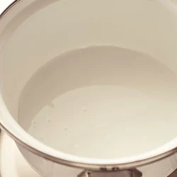 鍋に砂糖と水を入れたら、少し傾けるなどして、水が全体にいきわたるようにする。