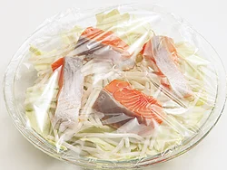 耐熱皿にキャベツ、もやしを敷いたあと、鮭を均等にのせ、ふんわりとラップをかける。
