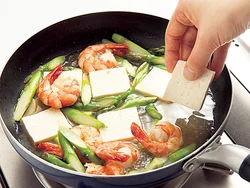 豆腐はくずれやすいので仕上げに入れる。えびやアスパラガスを寄せて、煮汁につかるようにして入れる。