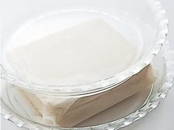 形がくずれないように豆腐をペーパータオルで包んでから、皿などでおもしをして水きりする。水分が抜けて扱いやすくなるので、豆腐の形を生かした揚げものや、チャンプルーなど豆腐に歯ごたえを出したい料理に向く。