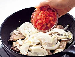 豚肉の両面にこんがり焼き色がついたら、玉ねぎ、トマトを加えてさっと混ぜる。熱を加えると玉ねぎとトマトの甘みが増しておいしくなる。