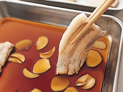 豚肉に漬けだれをからめる。豚肉は薄く切ってあるので短時間でも味がしみこみやすい。