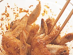 手羽先は熱いうちにヤンニョンジャンとあえて、味をよくからめる。