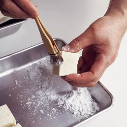 はけを使うと豆腐に片栗粉を薄くまぶすのがラク。片栗粉をはけにつけ、豆腐に軽くたたきつけるようにするとよい。