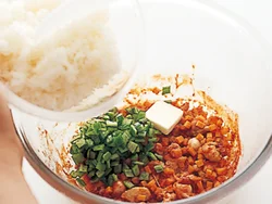 とり肉と野菜にケチャップなどの調味料を加えて加熱したところに、ご飯を加える。