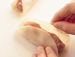 包むときは、餃子の皮の両端を折り重ねるだけ。あんに片栗粉を混ぜてあるので、餃子を焼くときに肉汁が流れ出にくい。