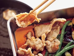 野菜、豚肉を揚げたら、油をきって、そのままつゆに漬けてからめる。熱いうちにつゆに漬けることで、味のしみ込みがよくなる。