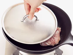 とり肉は皮目を下にして入れ、フライパンよりも少し小さめのふたをのせて焼く。肉が平らになることで皮をカリッと焼けるうえ、熱がまわりやすくなる。