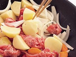 じゃがいもなどの野菜を炒めてから、牛肉を加えて炒め合わせると、肉のうまみが野菜になじむ。