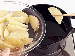 じゃがいもはまるごと電子レンジで加熱してから、くし形に切って揚げ油へ。切り口のほっくりした部分がカリカリになっておいしい。