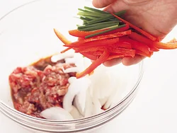 牛肉に<span class="dictionary_link" id="cook_191">下味</span>をよくもみ込んでから、さらに野菜も加えて混ぜ合わせる。