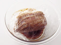 肉はラップで落としぶたをして、余熱調理でやわらかく仕上げ、味をなじませる。