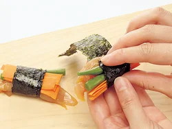 ささ身、にんじん、さやいんげんをのりでくるくると巻く。巻き終わりははずれないように水少々をつけて留めて。