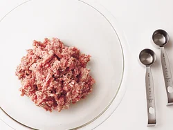 ひき肉300gに対し、水大さじ２(30ml)を加えて練り混ぜる。水を加えることでひき肉が水分を含み、揚げるとふっくらで肉汁の詰まったメンチカツになる。