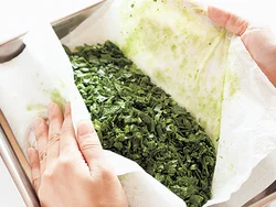 ほうれん草はしっかり水けをふくことで、えぐみが抑えられる。水けが多いので、ペーパータオルを２枚を重ねて使うとよい。