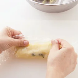 ラップの上から少しずつ横に細長くのばしていく。チョコレートはある程度のかたさがあるのでまとめやすい。