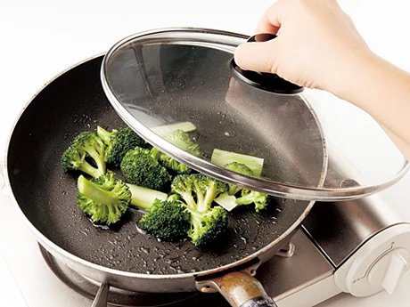 ブロッコリー全体に油がまわったら、水を加えてふたをする。ゆでるよりも野菜の甘みを感じられる仕上がりに。