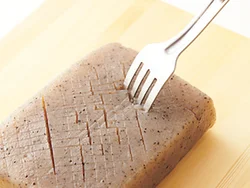 肉の代わりのこんにゃくは、包丁で切り込みを入れ、さらに穴をあけ、下味や肉のうまみをしっかりしみこませて。