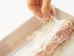 パン粉は細かいほうが油の吸収が抑えられるので、すりこ木でさらさらになるまで細かくする。
