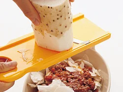 長いもは、スライサーを使って器に入れれば包丁で切るより手も汚れにくい。半量ずつ重ねるごとに、スライスする。