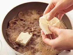 豆腐は手で大きめにちぎり、鍋にそっと加える。包丁で切るよりも断面が増えて、豆腐に煮汁がしみやすくなる。