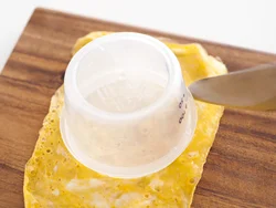 薄焼き卵にすし飯の容器を当て包丁を使ってくりぬけば、きれいな円形ができる。