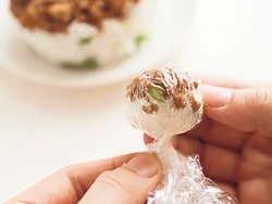 くまの耳は、ラップにそぼろを置いてすし飯と一緒に茶きんに絞る。その時、そぼろがばらばらにならないよう、かたく絞る。