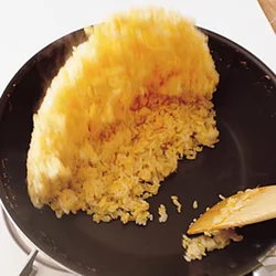 ご飯が充分にほぐれたら、木べらを手前から奥に動かして、空気を入れるように上下を返し、ご飯がパラパラになるまで炒める。写真のようにあおって炒めても。