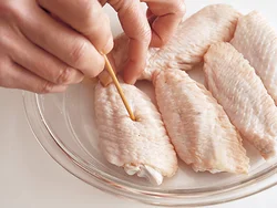 手羽中は、火の通りをよくし、味をしみこみやすくするために、皮目に竹串で穴をあけておく。
