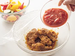 手羽元と香味野菜、カレー粉などを加熱し、肉のうまみやカレーの風味を引き出してからトマトを加える。