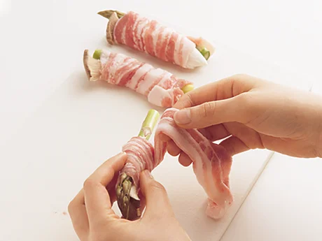 豚肉1枚を広げ、アスパラガスとエリンギにしっかり巻きつける。肉が重なりすぎないように、ずらしながら巻く。