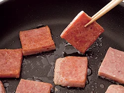 ランチョンミートは両面をこんがり焼きつけて、こうばしさ、脂のうまみを引き出す。
