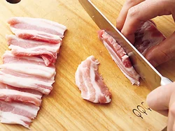 かたまり肉を食べやすい長さに切り分けたら、さらにその肉を薄切りに。肉がやわらかく感じられるように肉の繊維に沿って切る。