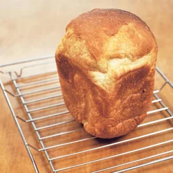 パンは網にのせてさます。こうして落ちつかせると切りやすくなる。パンを切るのに自信がない場合は、横に倒して側面から切るときれいにできる。