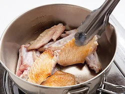 手羽先は焼きつけてから煮ることで、肉のうまみが閉じ込められる。だしが出る先端も一緒に加えて。