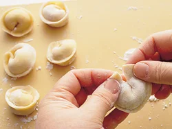 あんをのせ、餃子の皮を閉じたら、端と端をくっつける。丸くなって帽子のような形に。