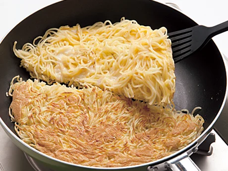 麺はこんがり焼き色がついたら上下を返す。返しやすくするために、半分に切ってから1切れずつ返す。