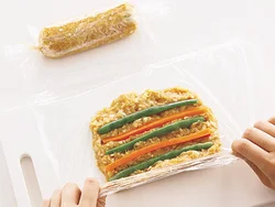 野菜は、ひき肉だねにすき間をあけて並べると、切り口がきれいに仕上がる。両端はねじったラップで縛るだけでOK。