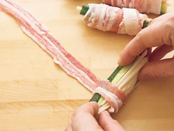 薄切り肉に、新しょうがのせん切りときゅうりを置き、肉が重ならないように少しずつずらしながらくるくると巻いていく。