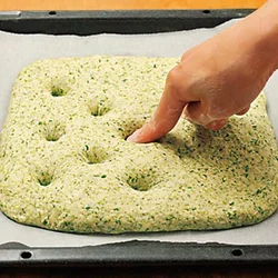 生地を大きく広げ、ところどころにくぼみをつけることで、ふくらみすぎを防ぎ、お店のような形のパンになる。