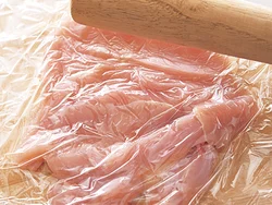 とり肉は切り開いてラップをかけ、めん棒でたたいて薄くのばすと直径25cm程度の大きさになる。短時間で中まで火が通るように。