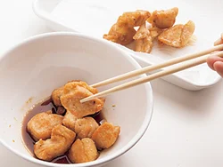 とり肉は揚げたてのうちに漬け汁につけると、味がよくからまる。菜箸でしっかり漬け汁をからめて。