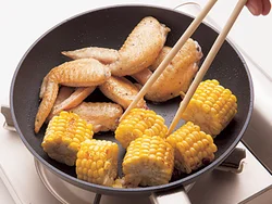 手羽先を焼きつけてからとうもろこしを加える。とうもろこしにもしっかり焼き目をつけるとこうばしくなる。