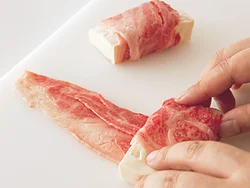 牛肉は大きければ、厚みが均等になるようにずらしながら豆腐に巻きつける。小さければ２枚をつなげて巻く。